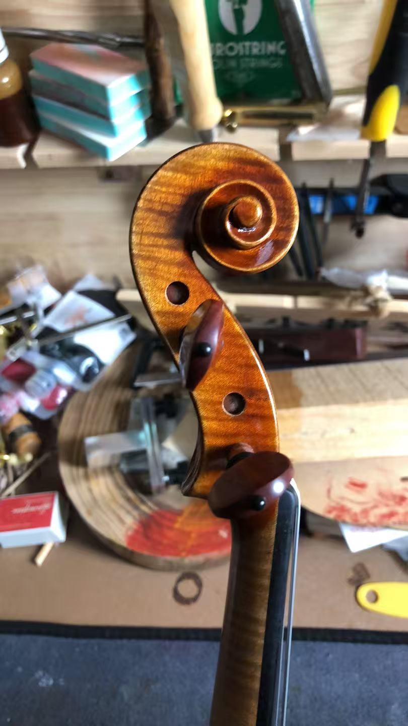 A finished handmade violin on the workbench in our workshop in Taixing, China